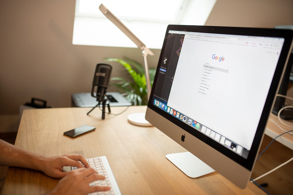 A modern workspace with an iMac displaying Google search, perfect for remote work setups.